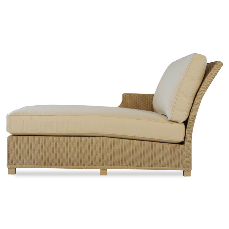 Beige wicker outdoor lounge chair with white cushions on a white background