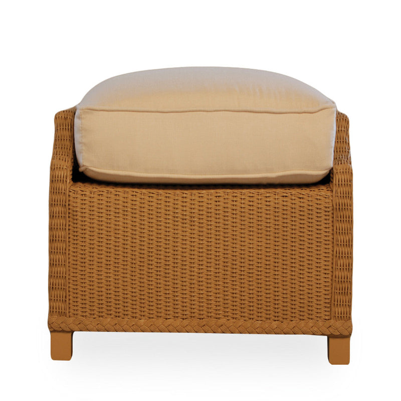 Wicker ottoman with a beige cushion on a white background