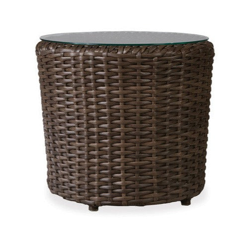 A 22-inch round Lloyd Flanders end table with a woven vinyl base and a clear glass top.