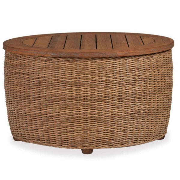 A round wicker cocktail table with a teak top and brown woven vinyl body, featuring a textured weave and a natural hyacinth finish.