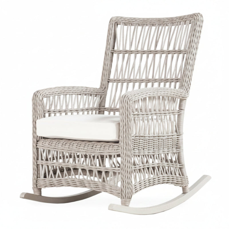 A beige wicker high back porch rocker with a teak wood top and white cushioning.