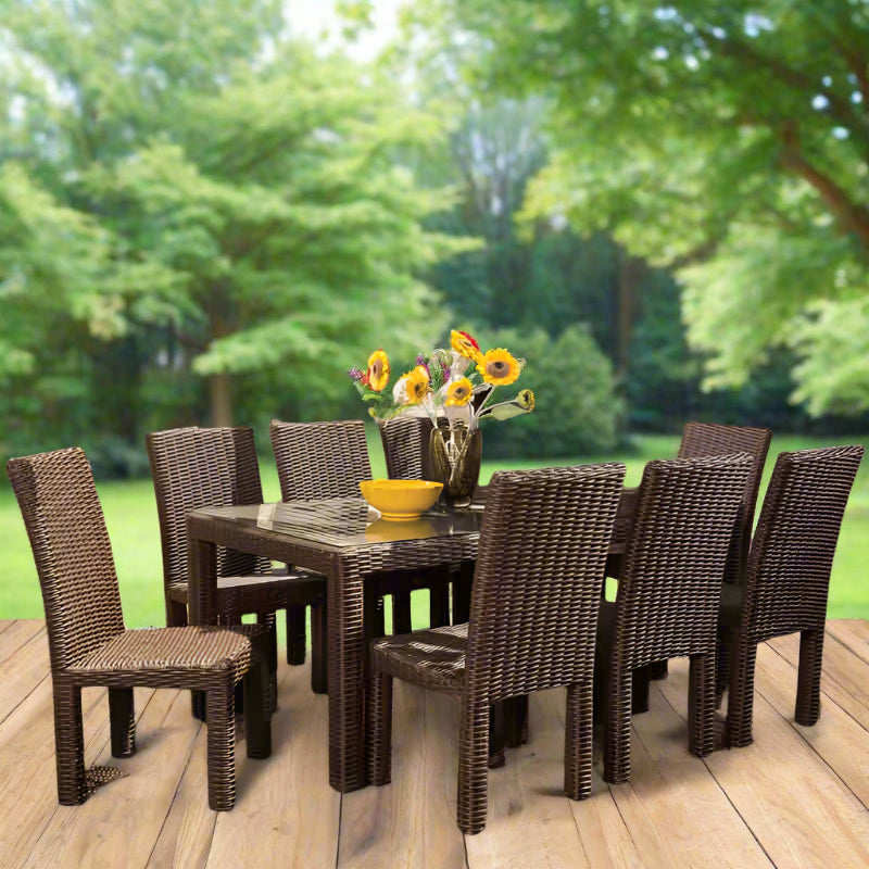 Outdoor dining set with a table and chairs on a wooden deck, surrounded by greenery.