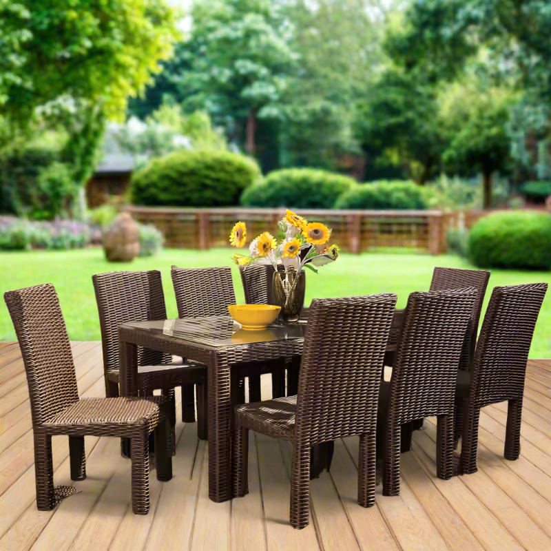 Outdoor dining set with table and chairs on a wooden deck, surrounded by greenery.