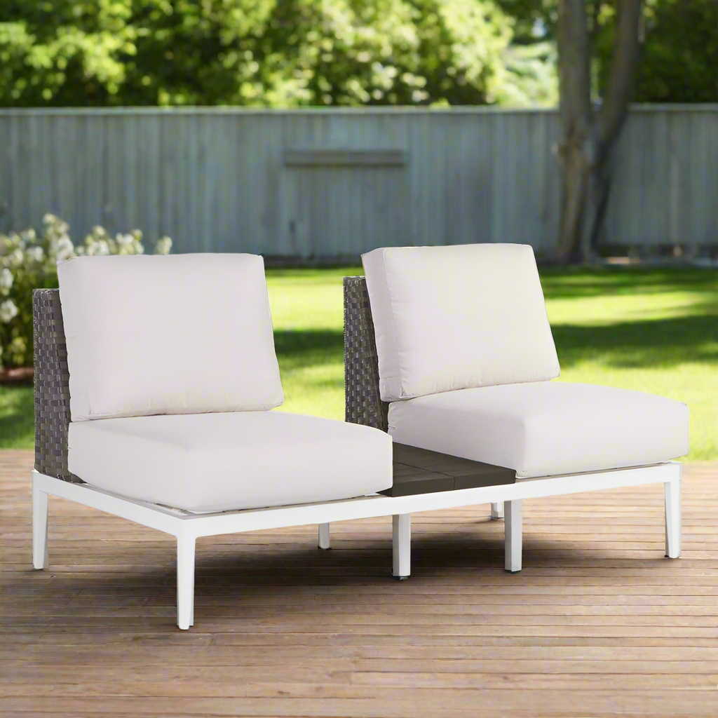 Two outdoor chairs with white cushions on a wooden deck.