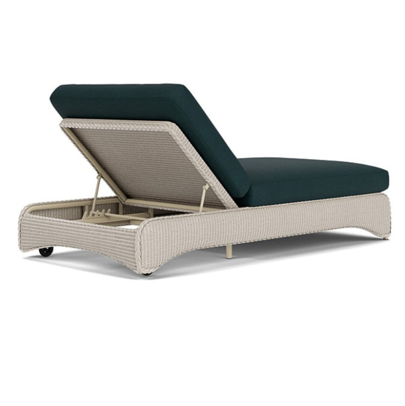 Beige outdoor lounge chair with dark blue cushion on a white background