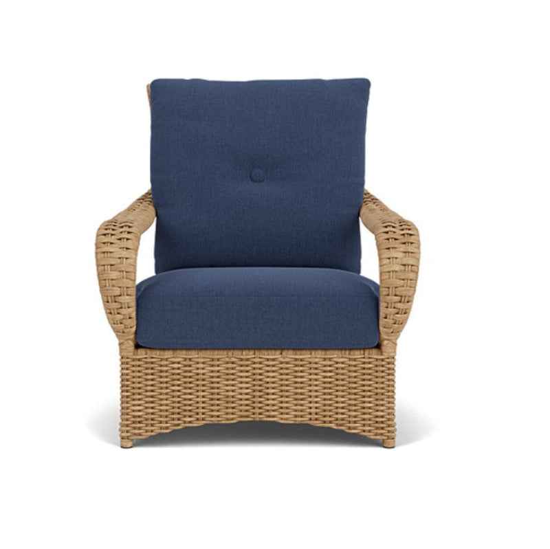 Wicker chair with blue cushions on a white background
