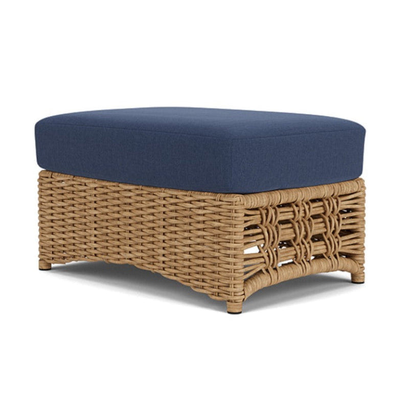 Wicker ottoman with a blue cushion on a white background