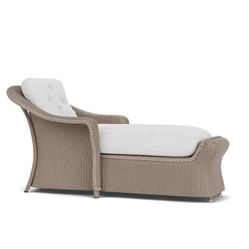 Wicker outdoor lounge chair with white cushions on a white background