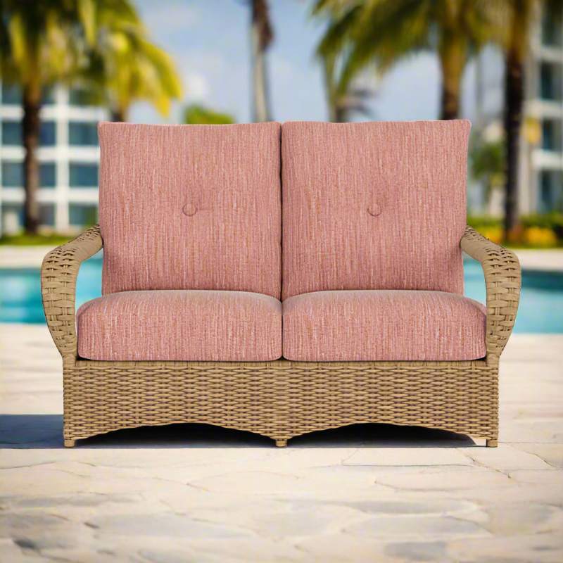 Wicker loveseat with pink cushions on a patio