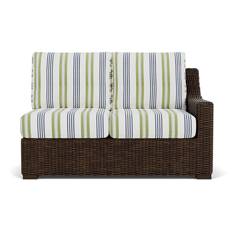 Wicker loveseat with striped cushions on a white background
