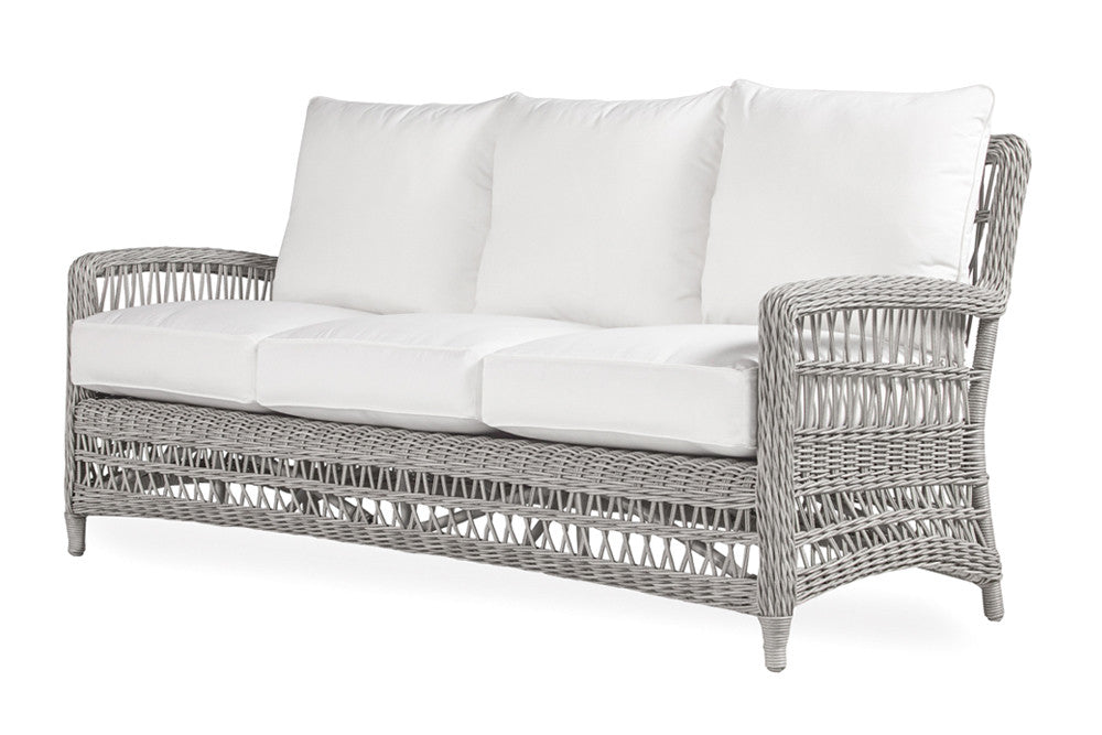 A wicker sofa with a rustic weave design and premium cloud cushioning, featuring a combination of gray and white colors.