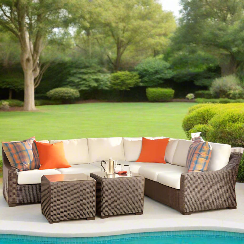 Outdoor patio furniture set with cushions on a stone patio.