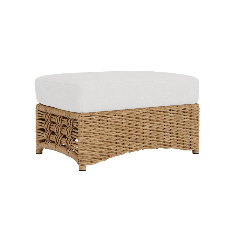 Wicker ottoman with a white cushion on a white background