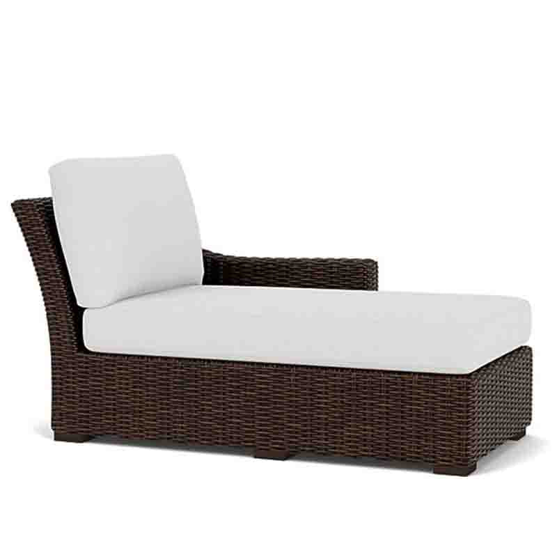 Wicker outdoor lounge chair with white cushions on a white background