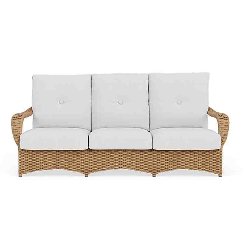 Wicker outdoor sofa with white cushions on a white background