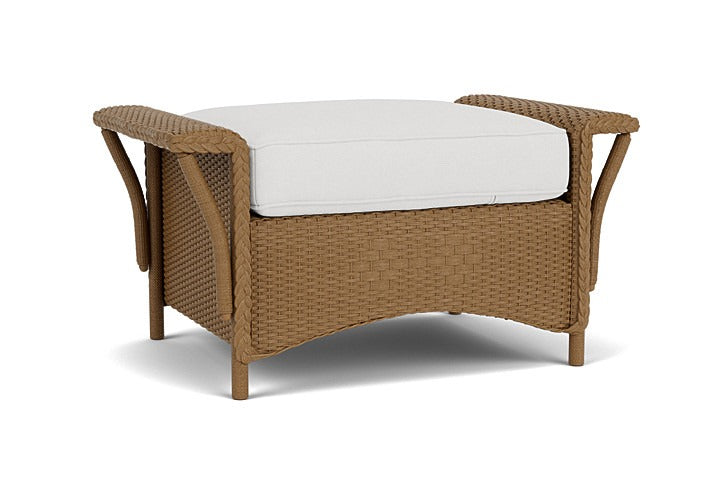 Wicker outdoor ottoman with a white cushion on a white background