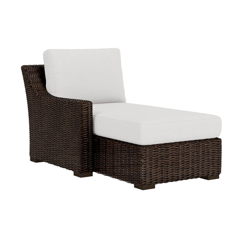 Brown wicker chair with white cushions on a white background