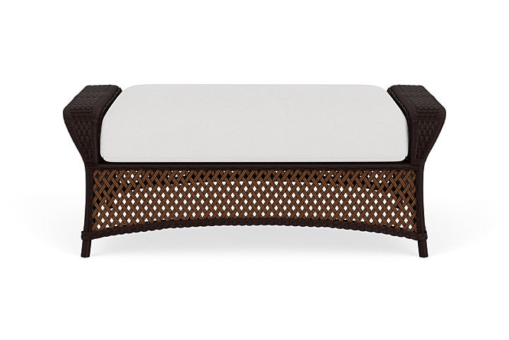 Wicker bench with a white cushion on a white background