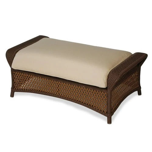 Wicker ottoman with beige cushion on a white background