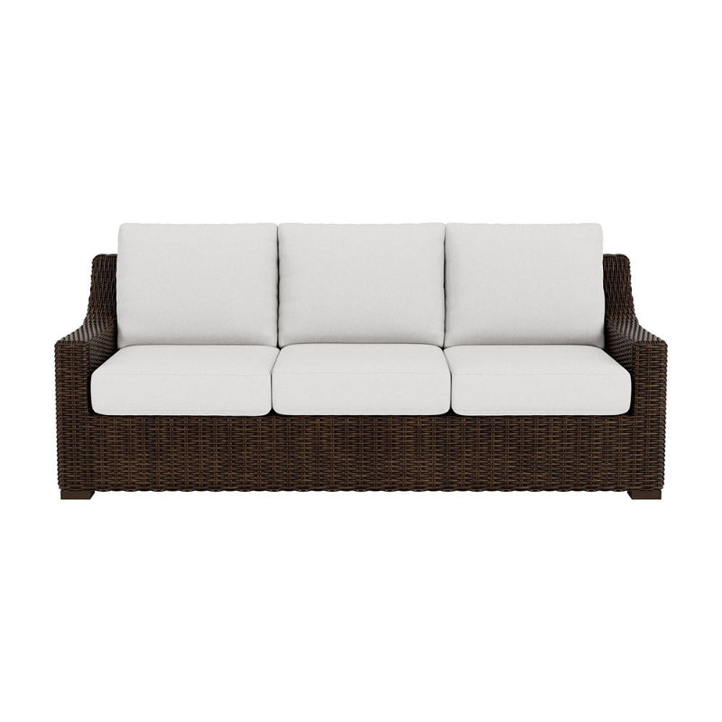 Wicker outdoor sofa with white cushions on a white background