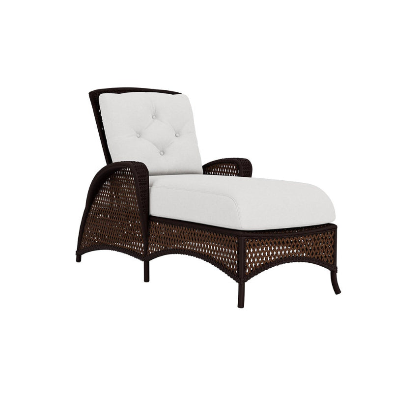 White cushioned lounge chair with brown wicker frame on a white background