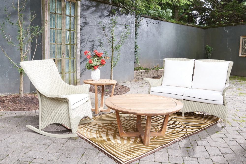 Outdoor patio set with a table, chairs, and a sofa on a stone patio.
