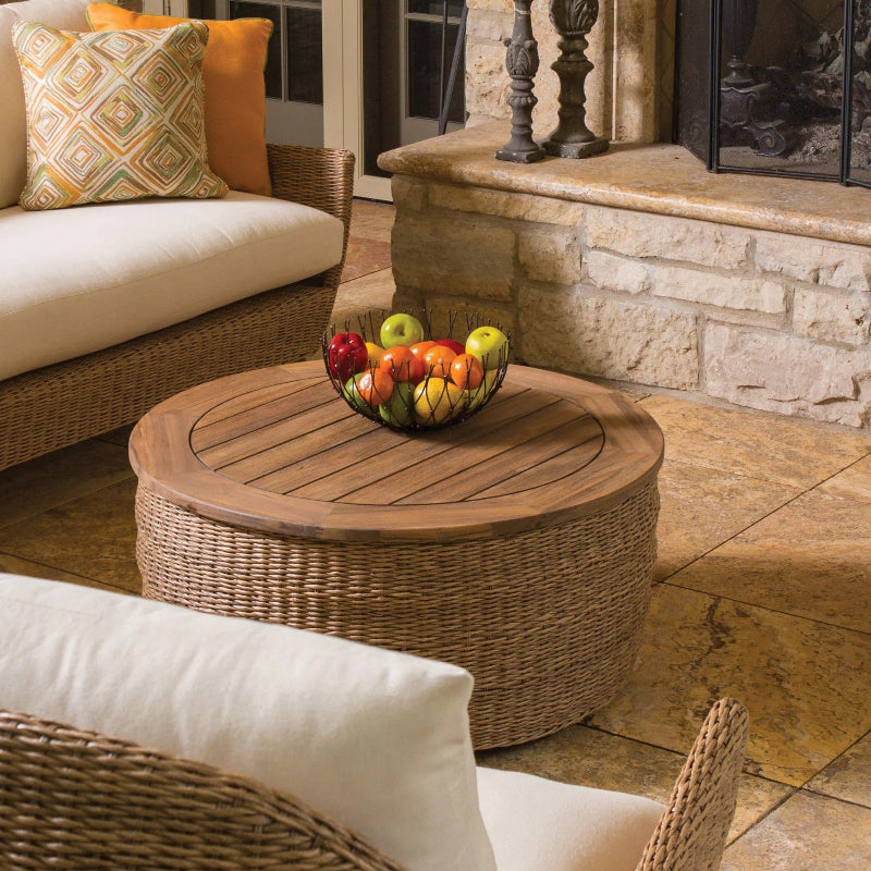 Outdoor patio setting with wicker furniture and a wooden coffee table.