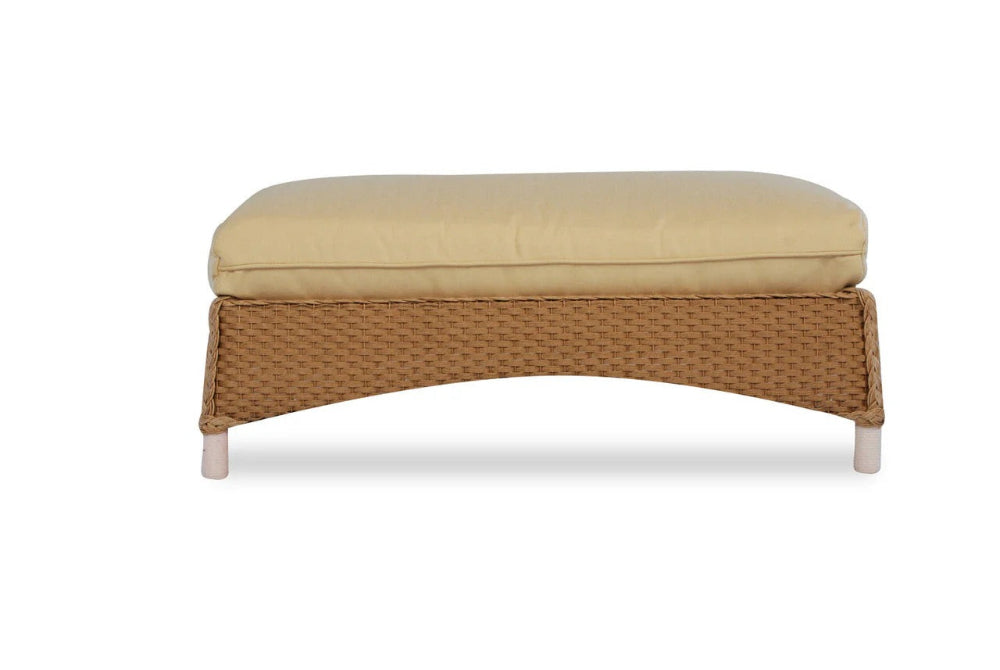 Wicker ottoman with beige cushion on a white background