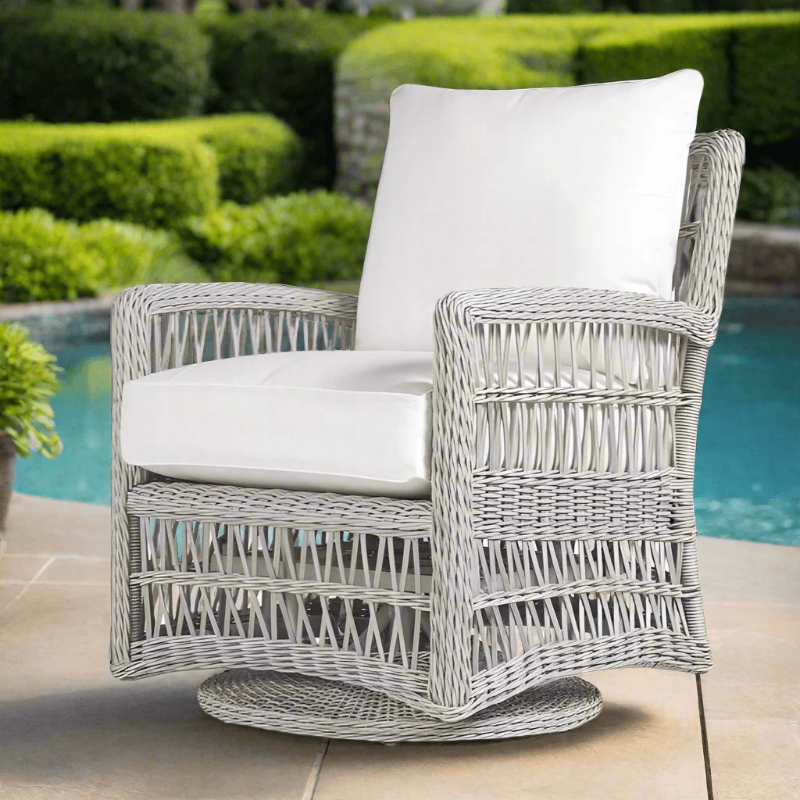 Wicker chair with white cushions by a poolside