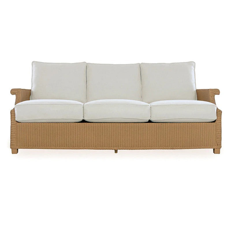 Wicker outdoor sofa with white cushions on a white background