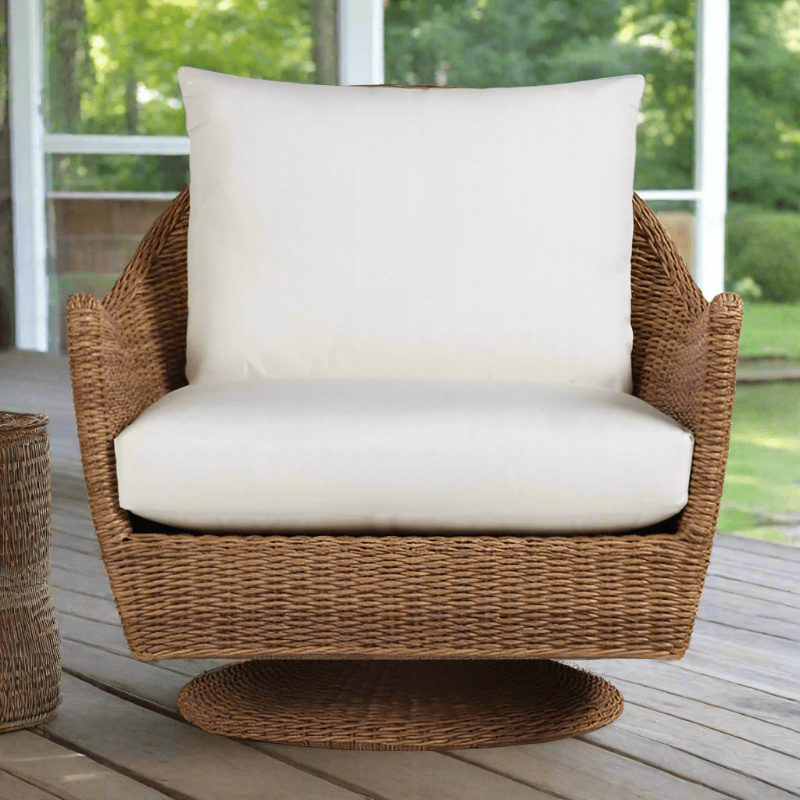 Wicker chair with white cushion on a wooden deck