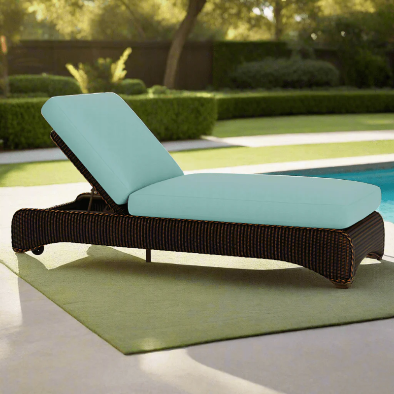 Chaise lounge with turquoise cushions by a poolside