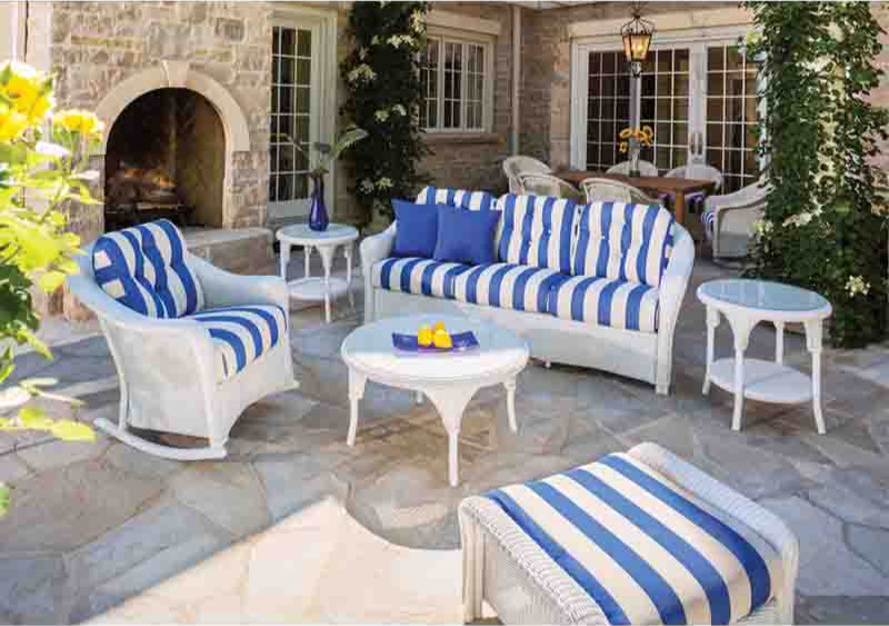 Outdoor patio set with blue and white striped cushions on a stone patio.