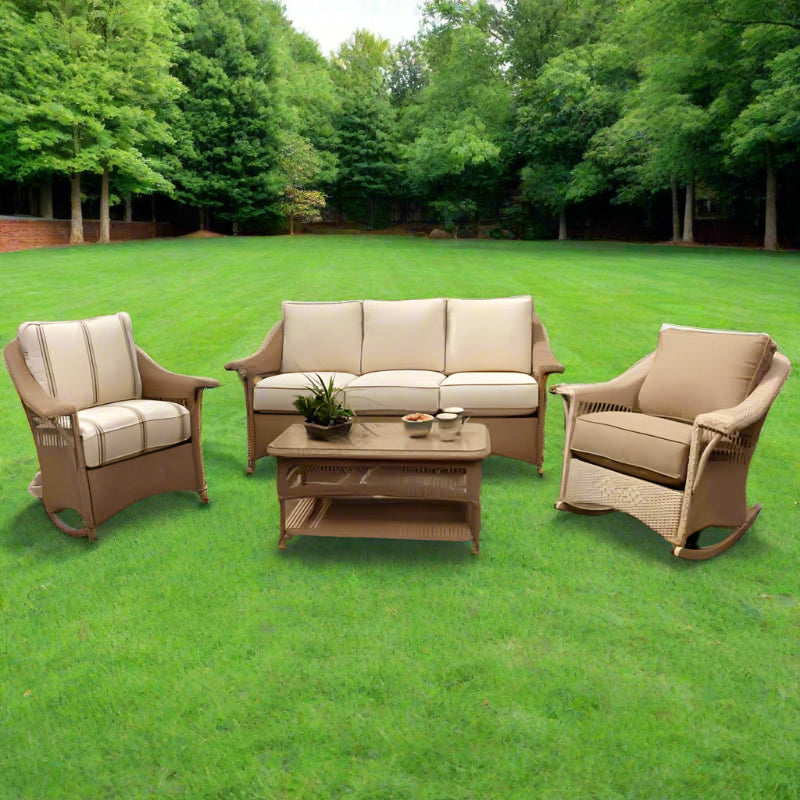 Outdoor patio furniture set with beige cushions on a stone patio.