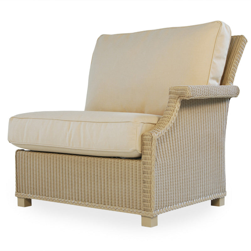 Beige wicker chair with cream cushions on a white background