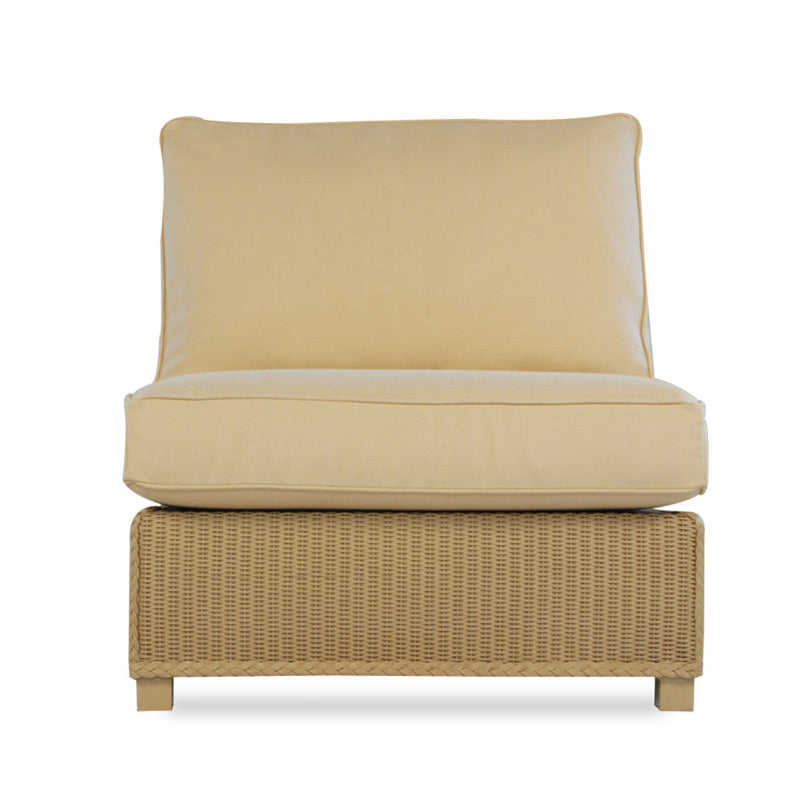 An armless sectional chair with a beige wicker frame and a beige cushion.