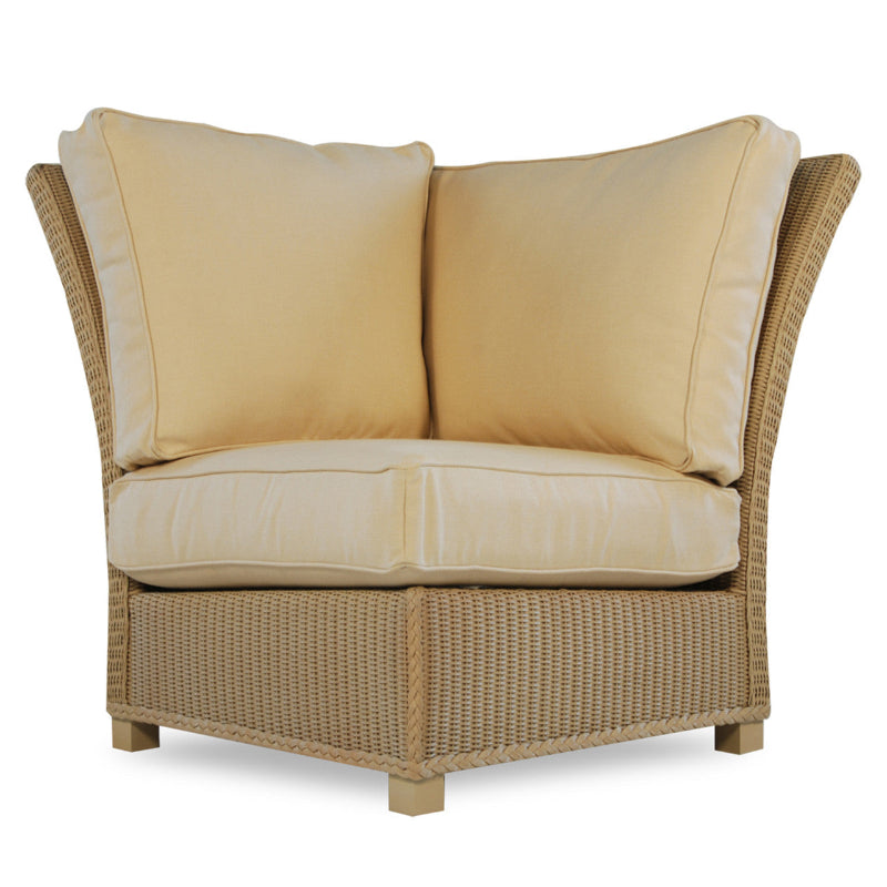 A beige wicker corner sectional chair with overstuffed cushions.