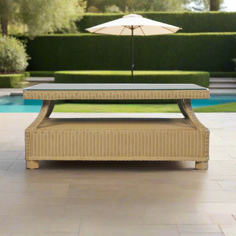 Wicker outdoor table with a pool and umbrella in the background