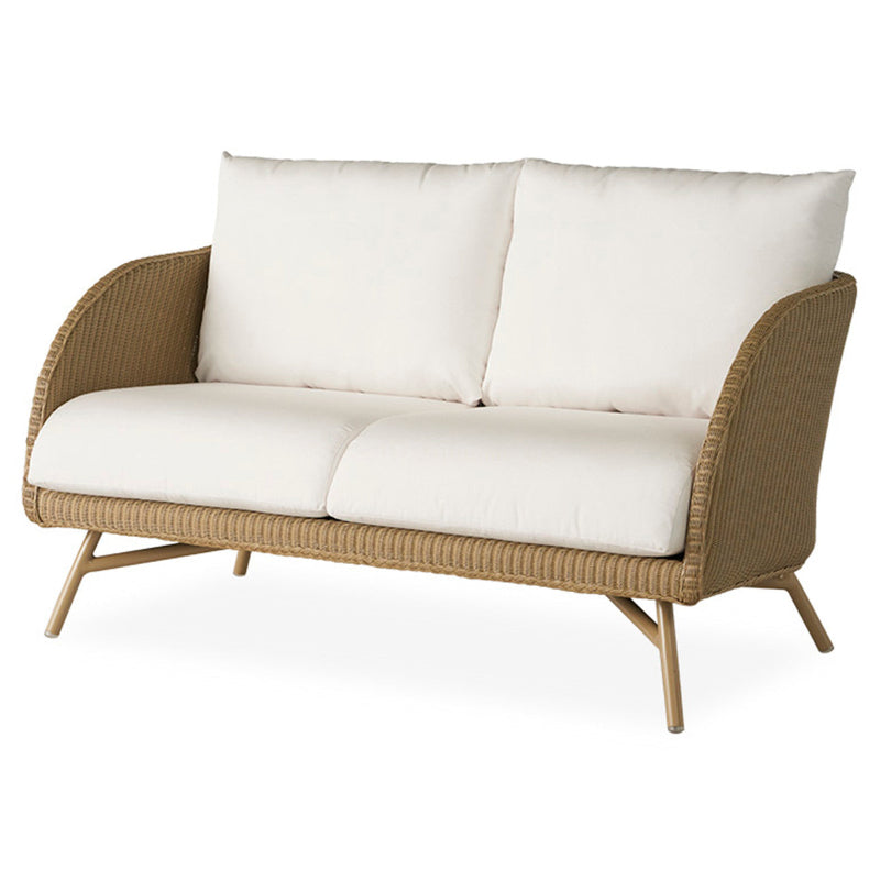 A beige wicker loveseat with white cushions, featuring a moderate scale and a retro oasis design for outdoor patio seating.