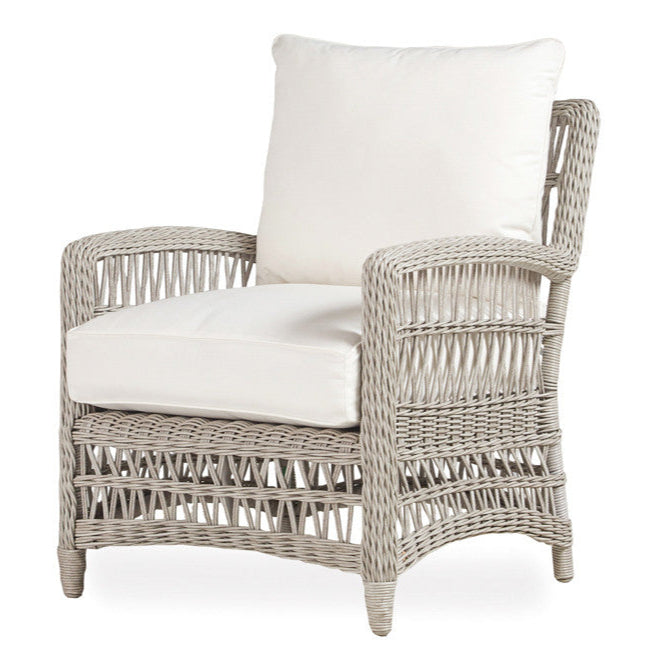 Wicker armchair with white cushions on a white background