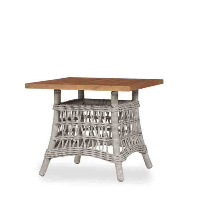 Square table with wooden top and wicker base on a white background