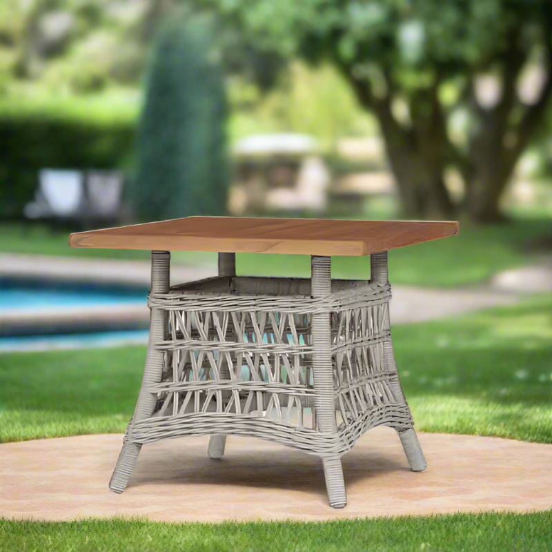 Outdoor table with wicker base and wooden top in a garden setting