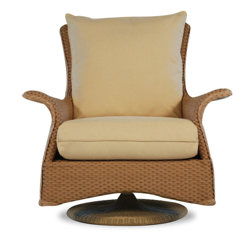 A beige wicker swivel rocker lounge chair with a loose back pillow and a flat, wide seat.