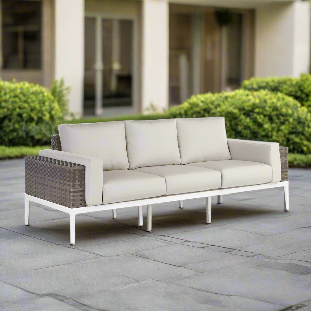 Outdoor sofa with beige cushions on a stone patio