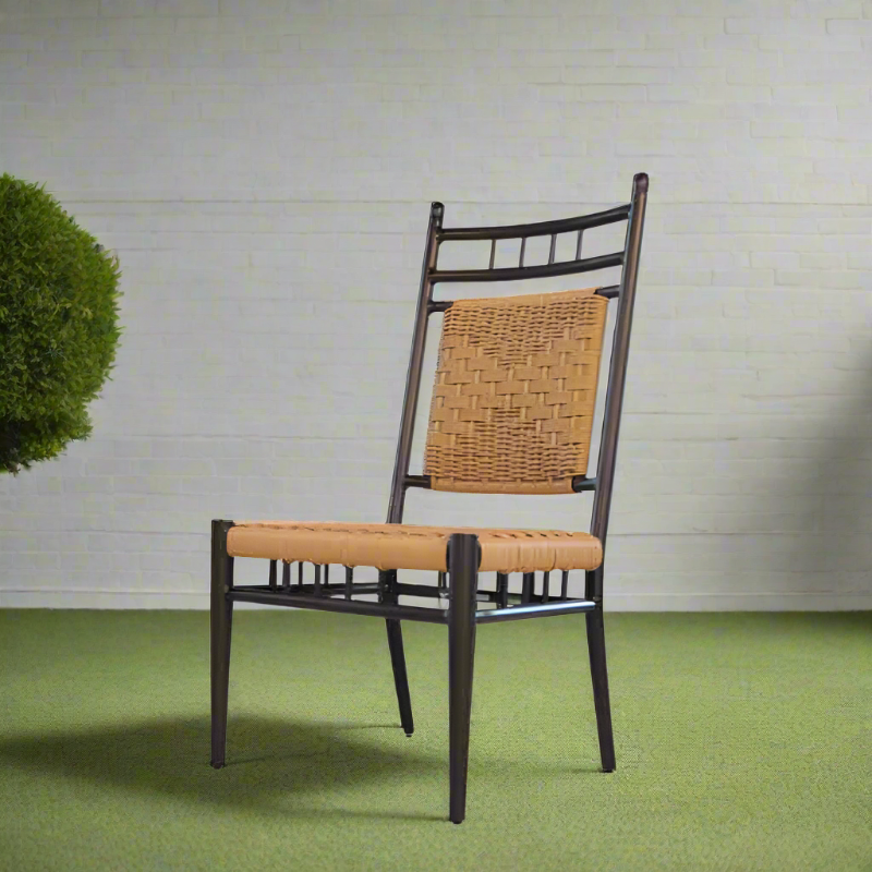 Chair with woven backrest and leather seat on a green floor and light gray wall background