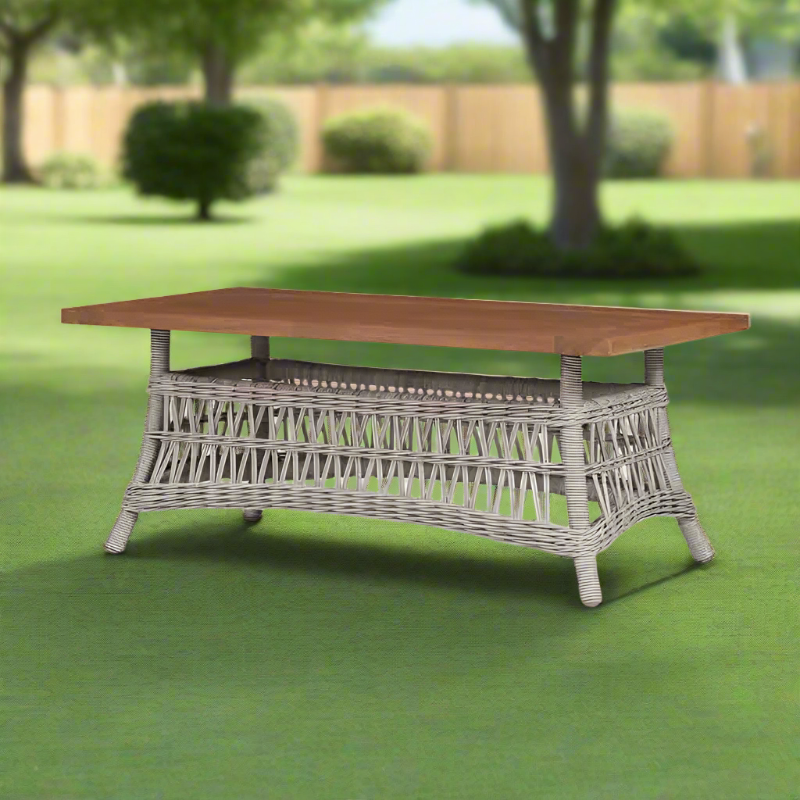 Garden table with wicker base and wooden top on grass