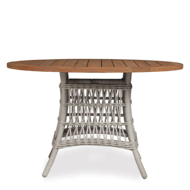 Round wooden table with wicker base on a white background