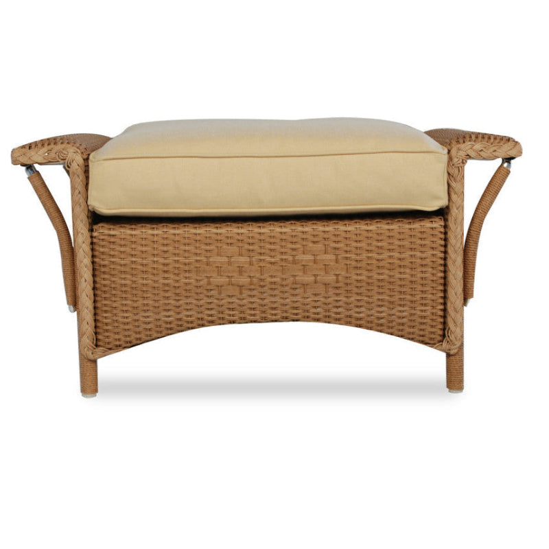 Wicker ottoman with beige cushion on a white background