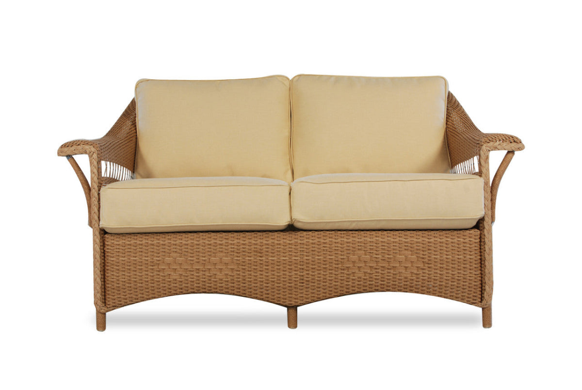 Wicker outdoor sofa with beige cushions on a white background