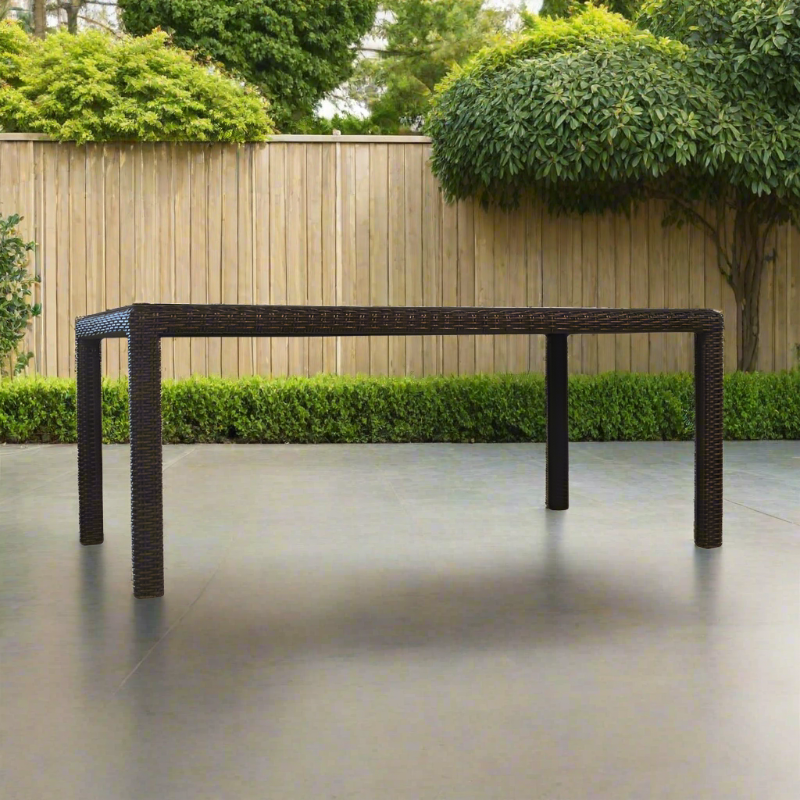 Rectangular outdoor dining table with wicker design on a patio